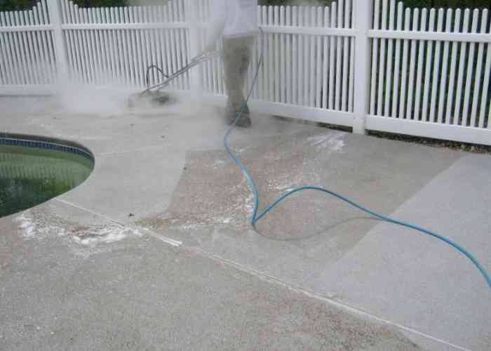 Stone patio getting sprayed with cleaning solution.